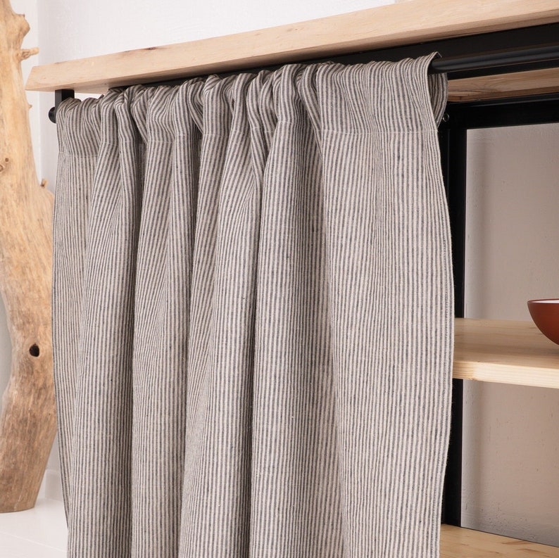 OEKO-TEX certified natural striped linen curtain in a stonewashed grey, draped elegantly as eco-friendly decor for a kitchen cupboard or bathroom shelf.