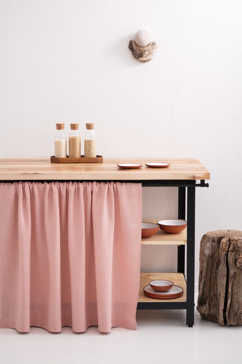 A Natural Linen Curtain in a soft pink hue hangs beneath a kitchen cupboard, showcasing OEKO-TEX certified eco-friendly decor and available in custom sizes.