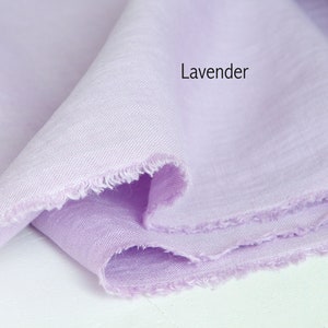 Close-up of a frayed edge of lavender organic linen fabric, showcasing premium European quality, available by the yard.