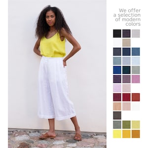 A woman stands confidently in white washed linen culottes and a yellow tank top, beside a swatch of modern colors.