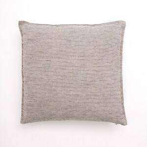 Puede incluir: Una almohada cuadrada a rayas con fondo beige y finas rayas grises oscuras. La almohada est&aacute; hecha de una tela suave y texturizada.