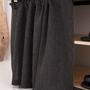 May include: Black and white striped linen curtains hanging from a wooden shelf with black metal brackets. The curtains are pulled closed, covering a shelf unit.