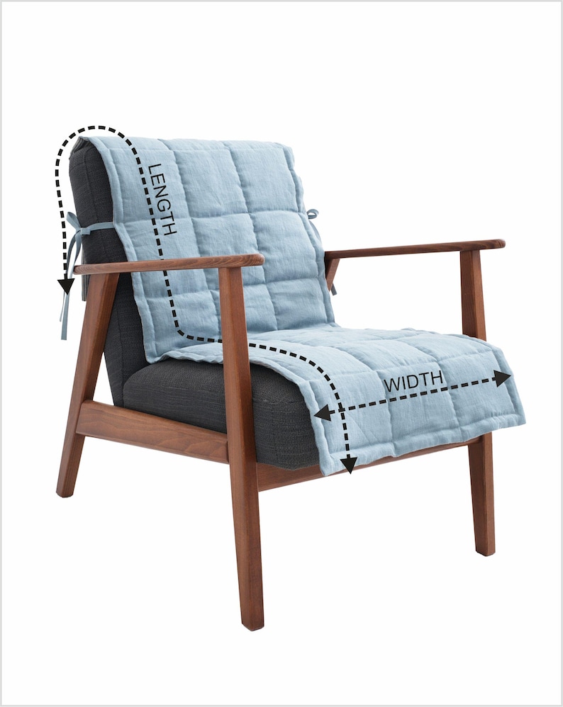 May include: A modern armchair with a light blue quilted seat cover. The chair has a dark gray seat and back, with wooden armrests and legs. The seat cover is designed to fit the chair's length and width.