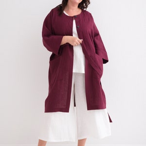 Woman in a "Comfortable and Stylish Plus Size Linen Maxi Coat with Pockets," a versatile washed linen duster, paired with a white dress and sneakers.