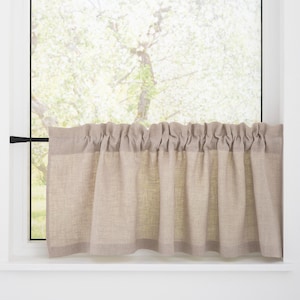 Può includere: Una tenda a valance in lino beige con un bordo superiore arricciato è appesa a una finestra con vista su un albero all'esterno.
