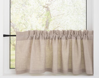 Puede incluir: Una cenefa de lino beige con un borde superior fruncido cuelga de una ventana con vista a un árbol en el exterior.