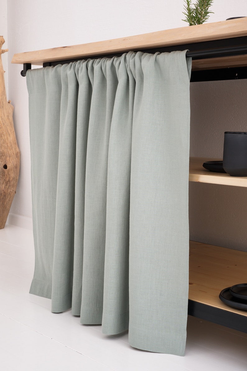 A custom-sized, stonewashed natural linen curtain in sage green, perfect for kitchen cupboards or bathroom shelves, featuring OEKO-TEX certification for eco-friendly decor.