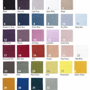 A color chart displaying 32 fabric swatches in various colors with labels ranging from Black, Charcoal, to vibrant shades like Mustard and Classic Blue, including neutrals like Optic White and Milk White.