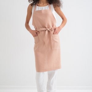 "Confident woman wearing a soft, peach plus size linen apron, ideal for cooking crafts and barbers."