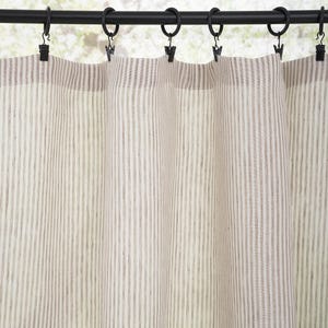 May include: A pair of white linen curtains with thin brown stripes hanging from a black curtain rod.