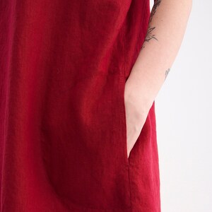 Puede incluir: Un vestido de lino rojo con un solo bolsillo de parche en el lado izquierdo.
