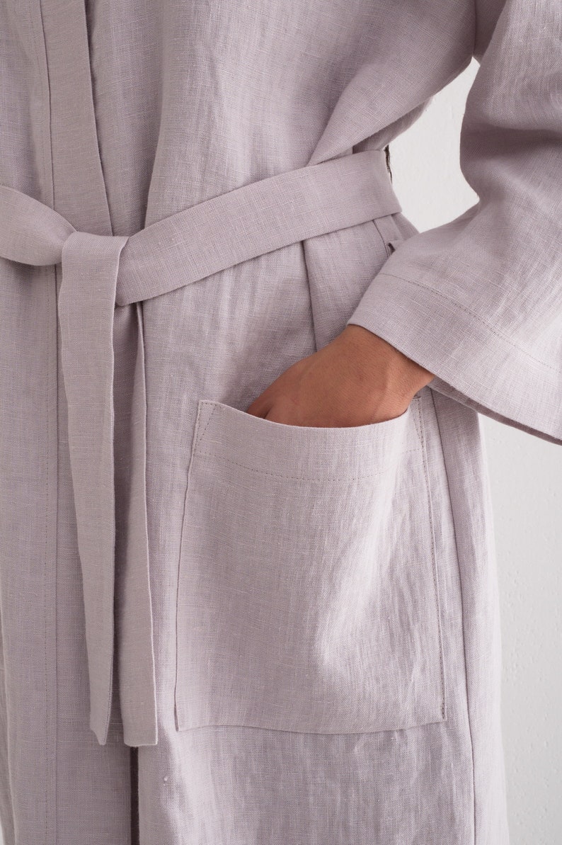 May include: A light purple linen robe with a self-tie belt and a patch pocket on the left side.