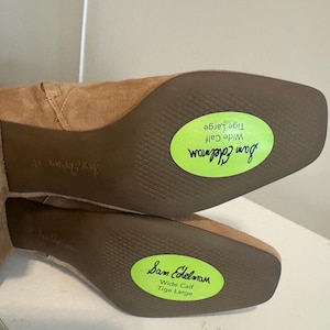 K&ouml;nnte beinhalten: Hellbraune Wildlederstiefel mit quadratischen Zehen und Blockabs&auml;tzen. Die Sohlen sind sichtbar, mit dem Markennamen "Sam Edelman" und einem gr&uuml;nen Aufkleber mit der Aufschrift "Wide Calf Tige Large".