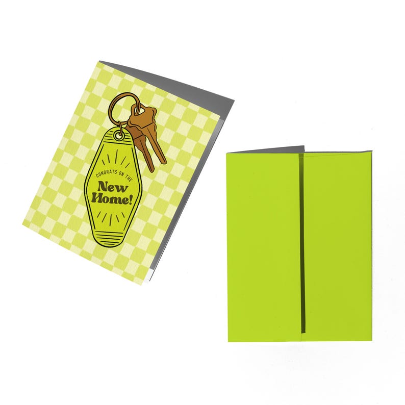 May include: A yellow and white checkered card with a key on a keychain in the shape of a hotel room key. The key has the text "Congrats on the New Home!" on it.
