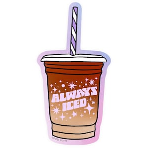 matte vinyl sticker with an illustration of a clear takeaway iced coffee cup with a gradient of lighter to darker brown. There is blocky lavender text that reads: "Always Iced" surrounded by stars and spots.