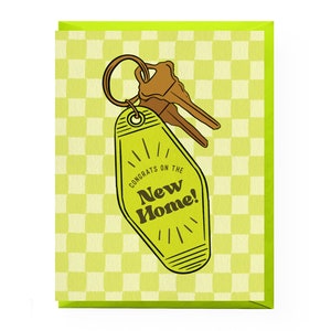 May include: A green and yellow card with a checkered pattern. The card features a cartoon illustration of a yellow motel key with the text "Congrats on the New Home!"