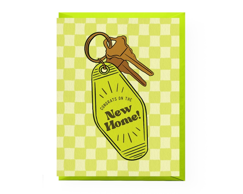 May include: A green and yellow card with a checkered pattern. The card features a cartoon illustration of a yellow motel key with the text "Congrats on the New Home!"