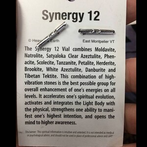Puede incluir: Un vial plateado etiquetado como "Synergy 12" con el texto "The Synergy 12 Vial combines Moldavite, Natrolite, Satyaloka Clear Azeztulite, Phenacite, Scolecite, Tanzanite, Petalite, Herderite, Brookite, White Azeztulite, Danburite and Tibetan Tektite."  El texto contin&uacute;a, "This combination of high-vibration stones is the best possible group for overall enhancement of one's energies on all levels. It accelerates one's spiritual evolution, activates and integrates the Light Body with the physical, strengthens one ability to manifest one's highest intention, and opens the mind to higher awareness."