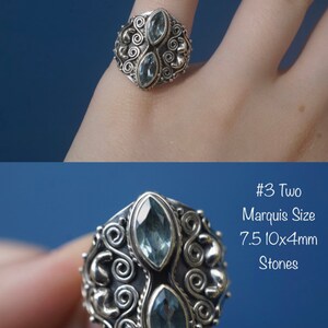 May include: Silver ring with two marquise-shaped blue stones set in a detailed, ornate design. #3 Two Marquise Size 7.5 10x4mm Stones