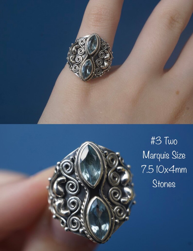May include: Silver ring with two marquise-shaped blue stones set in a detailed, ornate design. #3 Two Marquise Size 7.5 10x4mm Stones