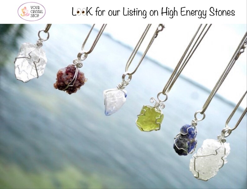 May include: Six silver necklaces with different colored crystal pendants. The crystals are wrapped in silver wire. The necklaces are hanging against a blue and white background.  "Look for our listing on High Energy Stones"