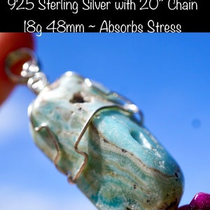May include: A Caribbean Calcite pendant from Pakistan, wrapped in 925 sterling silver with a 20 inch chain. The pendant is light blue and green with white streaks and measures 18 grams and 48 millimeters. The text "#3. Caribbean Calcite From Pakistan 925 Sterling Silver with 20" Chain 18g 48mm ~ Absorbs Stress" is visible in the image.