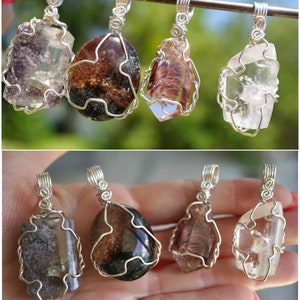 May include: Six wire-wrapped crystal pendants, featuring clear quartz, smoky quartz, and green amethyst crystals. The pendants are displayed on a silver wire and in a hand.