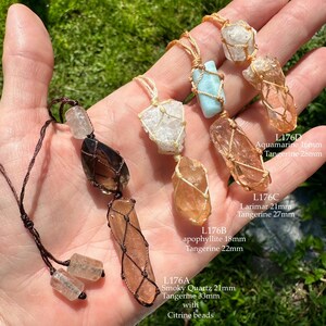 May include: Four crystal necklaces featuring different stones, including smoky quartz, apophyllite, larimar, and aquamarine. Each stone is wrapped in a macrame net and hangs from a brown cord. The necklaces are labelled with the stone type and size in millimetres.