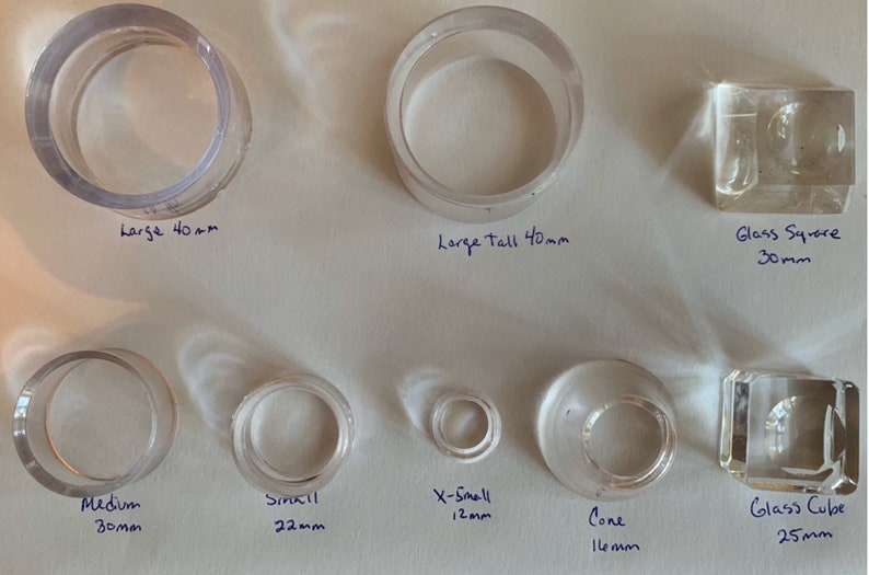 May include: Assortment of clear glass rings and cubes in various sizes. The rings are labeled "Large 40mm", "Large Tall 40mm", "Medium 30mm", "Small 22mm", "X-Small 12mm", and "Cone 16mm". The cubes are labeled "Glass Square 30mm" and "Glass Cube 25mm".