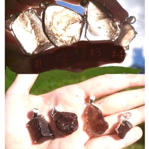 May include: Four different crystal pendants, two clear and two dark brown, with silver bail settings. The pendants are numbered 1 through 4.