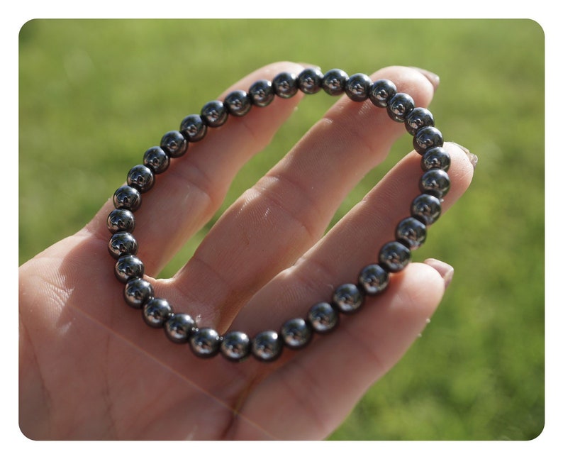 Puede incluir: Un brazalete negro hecho de cuentas redondas, lisas y brillantes de hematites.