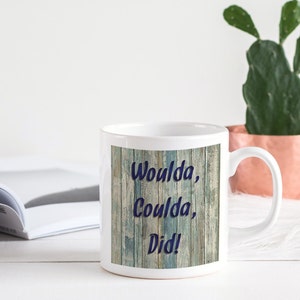 Può includere: Tazza in ceramica bianca con un design a effetto legno e il testo "Woulda, Coulda, Did!" in lettere blu.