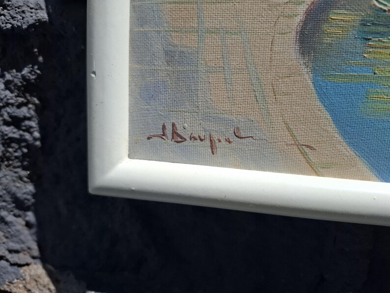 May include: A framed painting featuring a light beige background with a grid of thin, pale blue lines. A dark blue, circular shape is visible on the right side. A brown, handwritten signature is located in the lower left corner of the canvas.