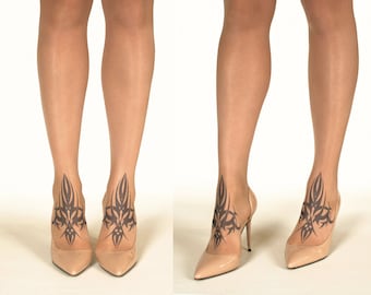 May include: A pair of nude-colored stockings with a black tribal design on the ankles. The stockings are worn with nude-colored high heels.