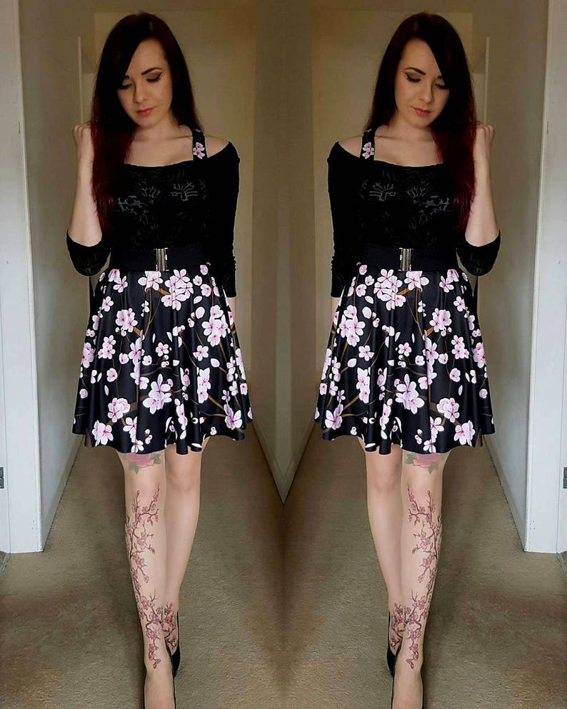 Puede incluir: Una mujer con un top negro de hombros descubiertos con un cintur&oacute;n negro, una falda floral negra y blanca y zapatos negros. Lleva medias con estampado floral.