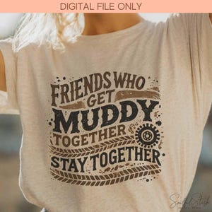 May include: Beige t-shirt with the text "FRIENDS WHO GET MUDDY TOGETHER STAY TOGETHER" in brown and black. The design includes tire tracks and a gear graphic, perfect for outdoor enthusiasts.