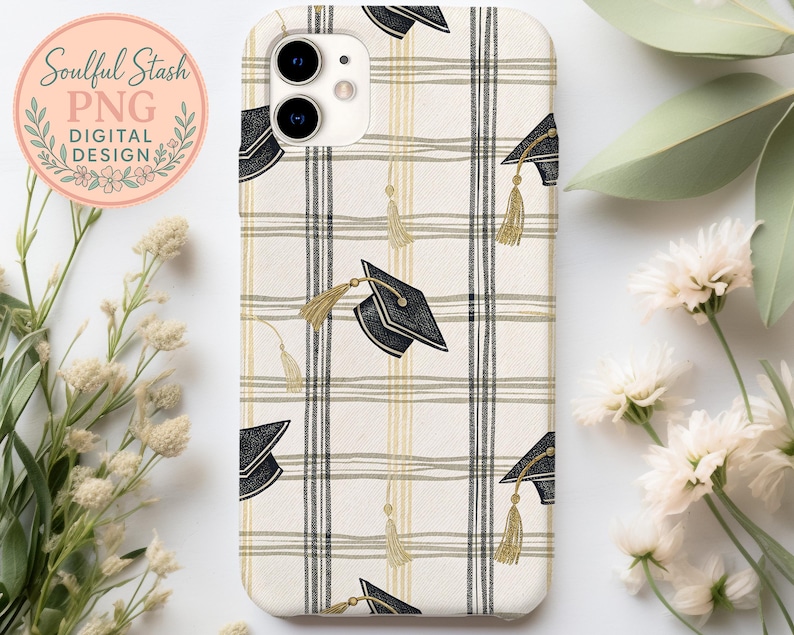 a phone case with a checkered pattern and graduation caps printed on it, placed on a white surface alongside some flowers and leaves.