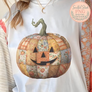 May include: White sweatshirt featuring a patchwork pumpkin design with a smiling jack-o'-lantern face. The pumpkin is composed of various floral and plaid patterns in shades of orange, yellow, and brown. A green stem and the text "Soulful Stash PNG DIGITAL DESIGN" are also visible.