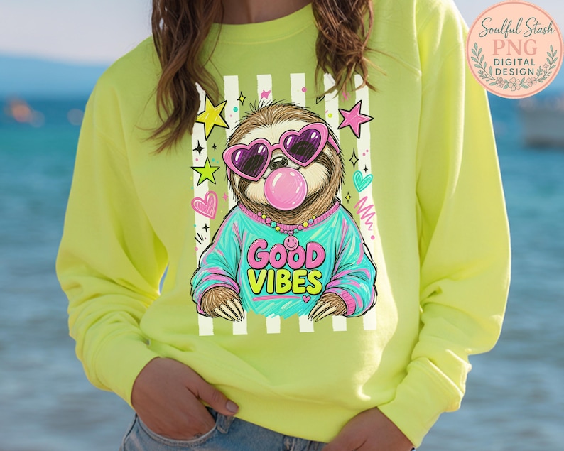 A person wearing a yellow sweatshirt with a graphic of a sloth wearing sunglasses and the text "GOOD VIBES" printed on it.