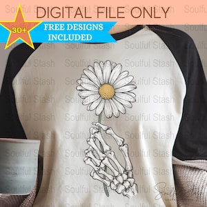 Puede incluir: Una camiseta blanca con una ilustración en blanco y negro de una mano de esqueleto sosteniendo una margarita. El texto "DIGITAL FILE ONLY" y "FREE DESIGNS INCLUDED" está impreso en la camiseta.