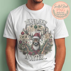 May include: White t-shirt featuring a deer wearing a Santa hat, antlers adorned with Christmas lights and ornaments, and two rifles. The text reads "REINDEER HUNTER" in a vintage style.