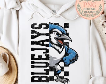 Puede incluir: Sudadera con capucha blanca con un gráfico de arrendajo azul y la palabra "BLUE JAYS" en letras negras. El arrendajo azul está representado en tonos azules, blancos y negros, con una expresión decidida. El diseño está sobre un fondo a cuadros.