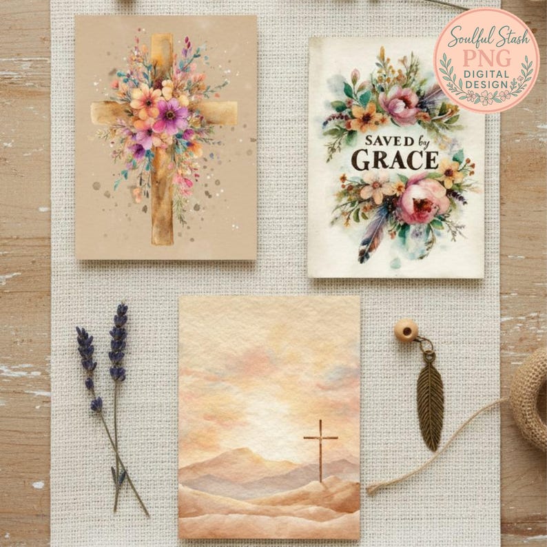 three different artworks or cards, each with a unique design and color scheme. The top card features a cross with a floral arrangement, the middle card has a floral design, and the bottom card has a landscape scene with a cross. There are also some dried lavender flowers and a feather pendant on the table.