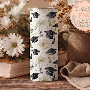a cylindrical object with a graduation cap and mortarboard design, surrounded by flowers and a book, all placed on a wooden surface.