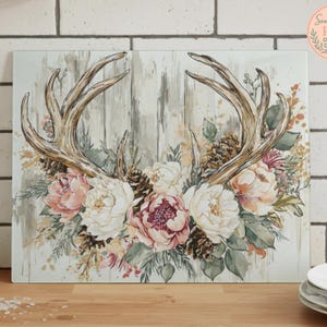 May include: Rectangular wall art featuring a watercolor design of deer antlers, flowers, and pinecones. The antlers are brown, and the flowers are pink, white, and burgundy. The background has a rustic, weathered wood appearance.