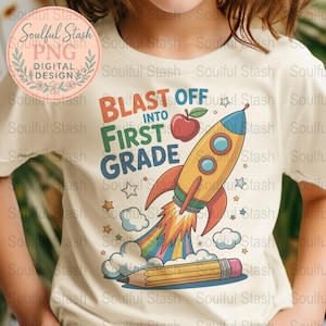 May include: Cream-colored t-shirt with a colorful graphic design. The design features a yellow rocket blasting off with a rainbow trail, an apple, stars, clouds, and a pencil. Text reads "BLAST OFF INTO FIRST GRADE."
