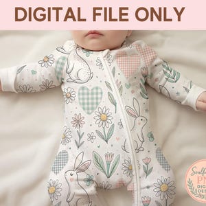 A baby wearing a white onesie with a floral pattern and a rabbit design.