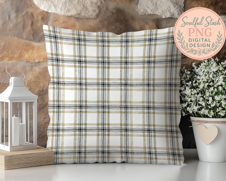a decorative pillow with a plaid pattern, placed on a wooden surface next to a potted plant and a lantern.