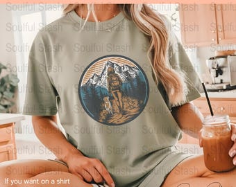 May include: A green t-shirt with a graphic of a person hiking with a dog in the mountains. The graphic is in a circle with a sunset background. The text "DIGITAL FILE ONLY" is at the top of the image.