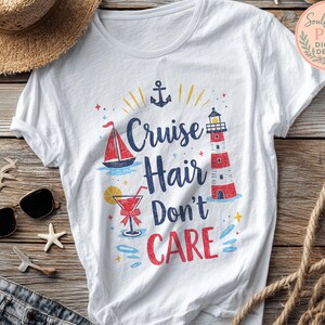 May include: White t-shirt with a colorful graphic design featuring a sailboat, lighthouse, and cocktail. The text reads "Cruise Hair Don't Care" in blue and red. A nautical-themed tee for a vacation.